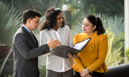 Businessman and businesswomen discussing over filed documents at office